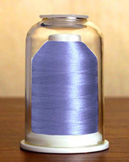 A spool of blue thread inside a clear dome on a wooden surface.